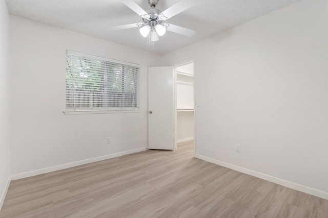 34 Quiet Peace Pl, The Woodlands, TX 77381 - spare room with light wood-type flooring, baseboards, and ceiling fan