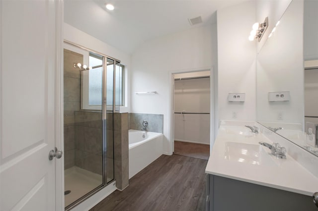 16129 Barge Way, Crosby, TX 77532 - full bathroom featuring wood finished floors, a shower stall, a bath, a walk in closet, and vaulted ceiling