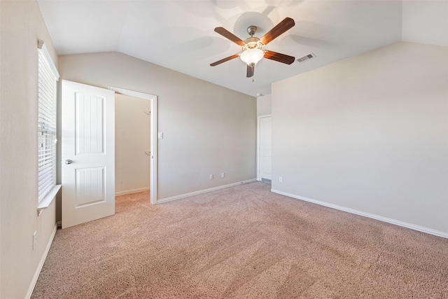 unfurnished bedroom featuring lofted ceiling, light colored carpet, baseboards, and ceiling fan