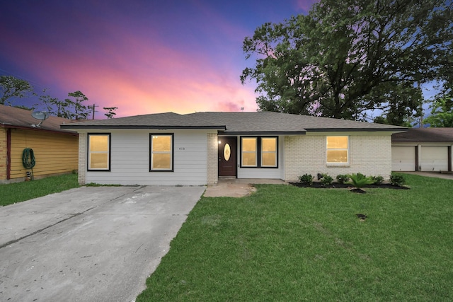 single story home with brick siding and a front yard