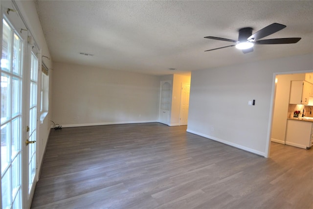 14459 Misty Meadow Ln, Houston, TX 77079 - spare room featuring a textured ceiling, ceiling fan, wood finished floors, and baseboards