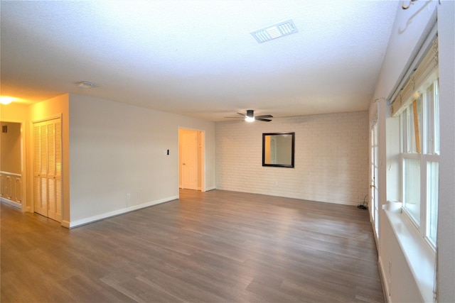 14459 Misty Meadow Ln, Houston, TX 77079 - spare room with brick wall, wood finished floors, baseboards, a ceiling fan, and plenty of natural light