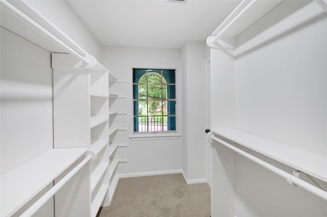 walk in closet featuring light carpet