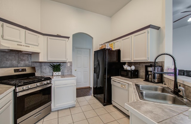3116 Grassmere St, Houston, TX 77051 - kitchen featuring black appliances, under cabinet range hood, a sink, white cabinetry, and a high ceiling