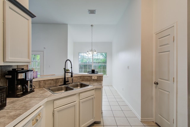 3116 Grassmere St, Houston, TX 77051 - kitchen featuring a sink, light tile patterned flooring, a peninsula, white dishwasher, and tile counters