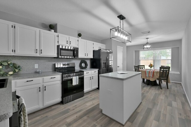 kitchen featuring stainless steel appliances, decorative backsplash, white cabinets, and light countertops