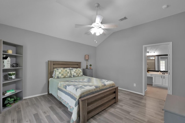 bedroom featuring light wood-style floors, lofted ceiling, baseboards, a sink, and a ceiling fan