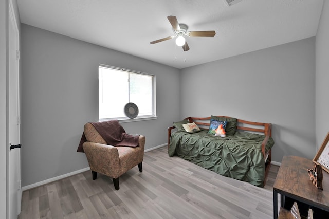 bedroom featuring wood finished floors, baseboards, and a ceiling fan