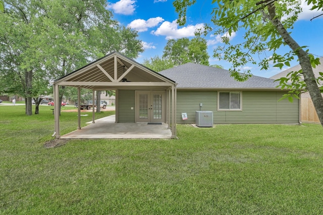 rear view of property with french doors, a yard, a patio, central AC, and roof with shingles
