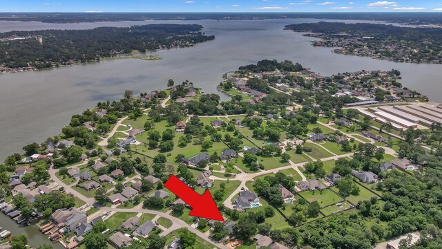 aerial view of property's location featuring a large body of water and nearby suburban area