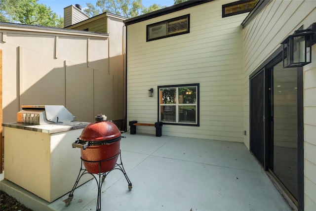 rear view of property featuring area for grilling, a patio, and a chimney