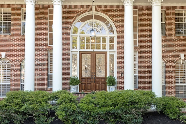 view of exterior entry with brick siding and french doors