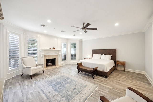 bedroom featuring ornamental molding, light wood-style floors, a high end fireplace, baseboards, and recessed lighting