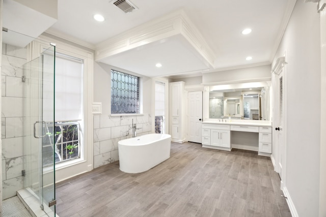 full bath with ornamental molding, a shower stall, wood finished floors, vanity, and a soaking tub