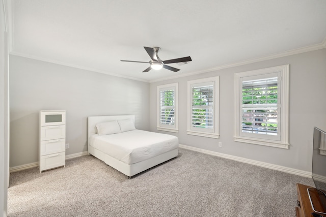carpeted bedroom with multiple windows, crown molding, baseboards, and a ceiling fan