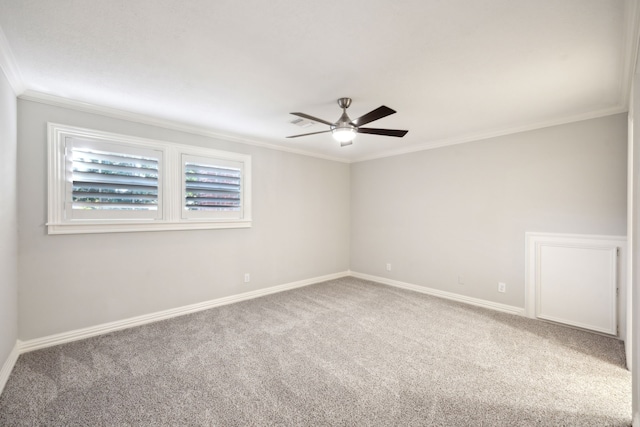empty room with ceiling fan, carpet flooring, crown molding, and baseboards