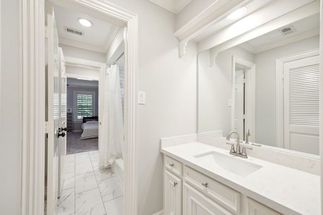bathroom with marble look tile flooring, crown molding, vanity, baseboards, and curtained shower