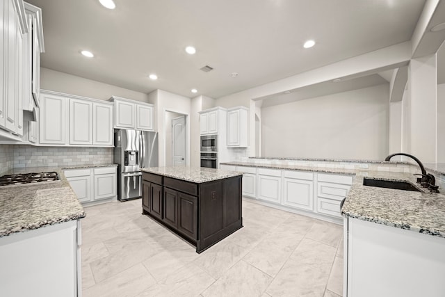28209 Regal Wood Ct, Spring, TX 77386 - kitchen with appliances with stainless steel finishes, a sink, tasteful backsplash, white cabinets, and recessed lighting
