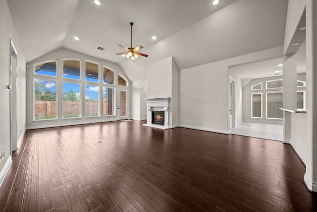 28209 Regal Wood Ct, Spring, TX 77386 - unfurnished living room with vaulted ceiling, a warm lit fireplace, healthy amount of natural light, a ceiling fan, and wood finished floors
