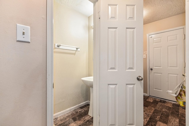 bathroom featuring a textured ceiling and baseboards