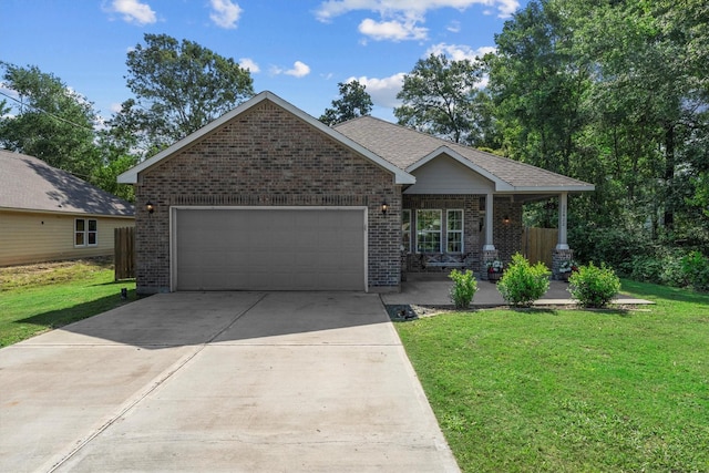 view of front of property with brick siding, a garage, a front yard, driveway, and covered porch
