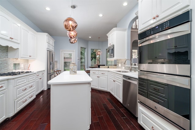 2130 White Eagle Ln, Katy, TX 77450 - kitchen with appliances with stainless steel finishes, a sink, a center island, arched walkways, and white cabinets
