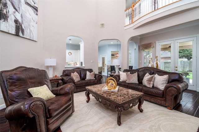 2130 White Eagle Ln, Katy, TX 77450 - living room featuring arched walkways, wood finished floors, a towering ceiling, and french doors