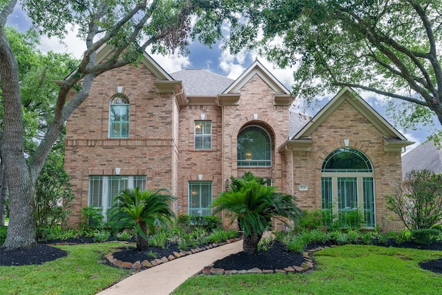 2130 White Eagle Ln, Katy, TX 77450 - traditional home with brick siding, a front yard, and roof with shingles