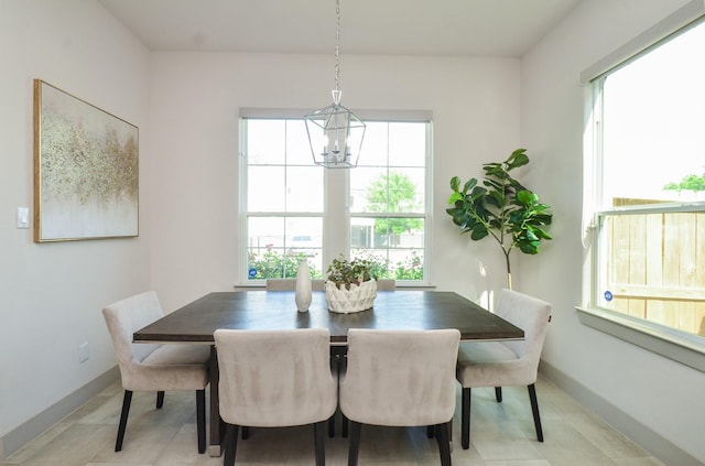 dining space with plenty of natural light, a chandelier, baseboards, and light tile patterned flooring