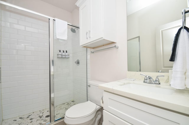 full bath featuring a stall shower, toilet, and vanity