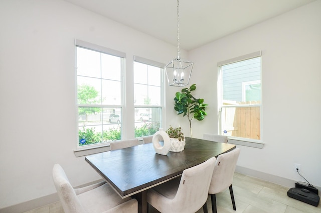 dining area with a chandelier and baseboards