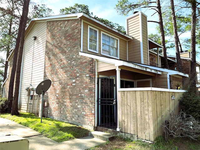 view of home's exterior with a chimney and brick siding