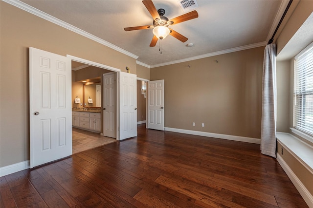 unfurnished bedroom featuring hardwood / wood-style flooring, ornamental molding, baseboards, ensuite bathroom, and a ceiling fan