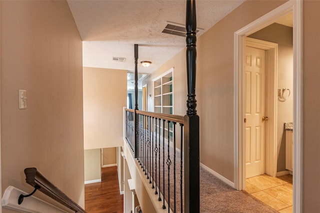 stairs featuring baseboards and a textured ceiling