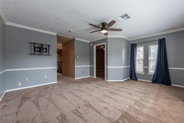 carpeted empty room featuring ceiling fan, crown molding, baseboards, and a textured ceiling