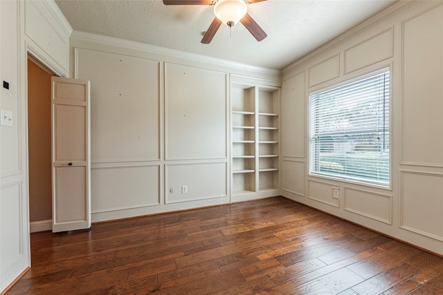 unfurnished room with a decorative wall, hardwood / wood-style flooring, ceiling fan, and built in shelves