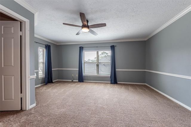 carpeted empty room featuring healthy amount of natural light, a textured ceiling, ceiling fan, ornamental molding, and baseboards
