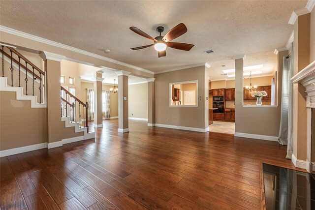 unfurnished living room featuring a chandelier, a ceiling fan, a textured ceiling, dark wood-style flooring, and baseboards