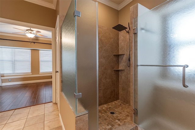 full bathroom with crown molding, a stall shower, a ceiling fan, tile patterned floors, and baseboards