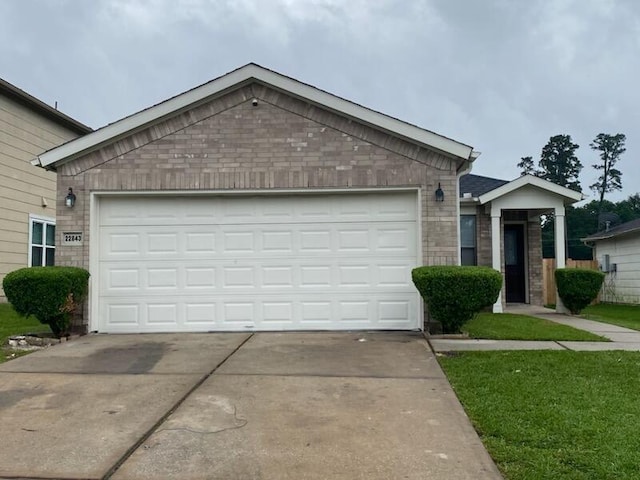 single story home featuring driveway, a garage, and brick siding