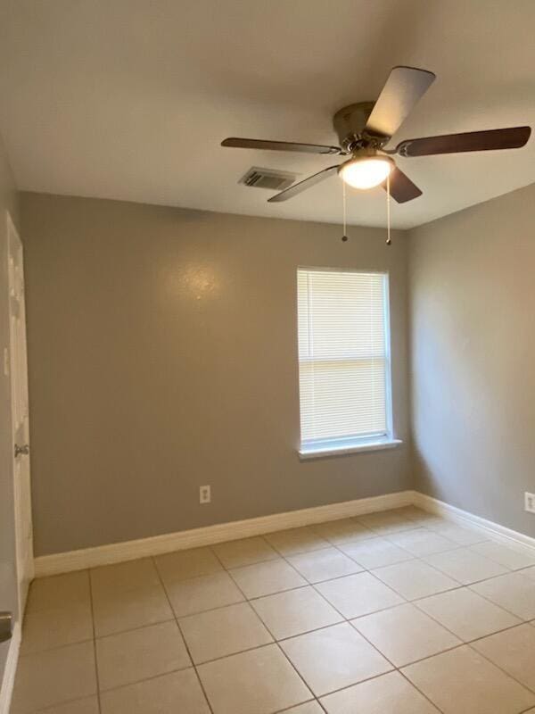 spare room featuring ceiling fan, light tile patterned flooring, and baseboards