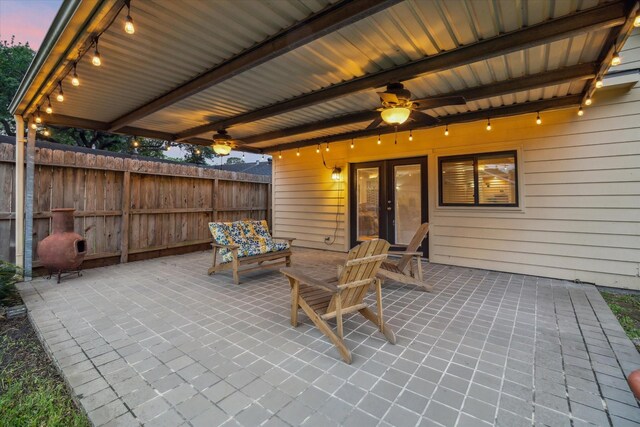 view of patio / terrace with a ceiling fan, fence, and french doors
