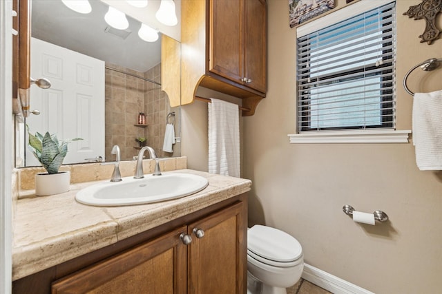 full bathroom featuring toilet, a shower, vanity, and baseboards