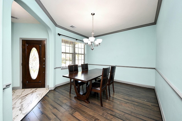 dining room featuring a chandelier, ornamental molding, dark wood-style floors, arched walkways, and baseboards