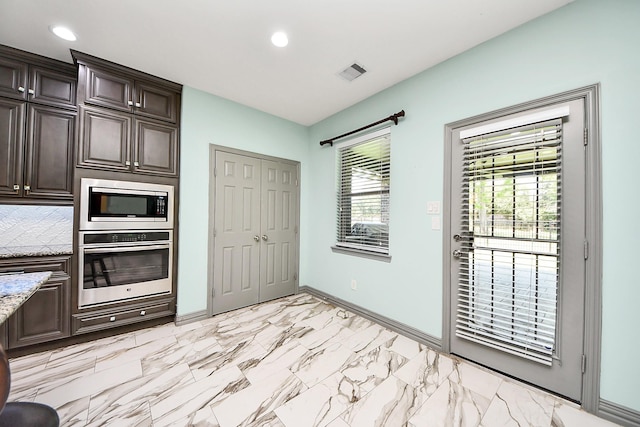 kitchen featuring stainless steel appliances, baseboards, light stone counters, dark brown cabinetry, and recessed lighting