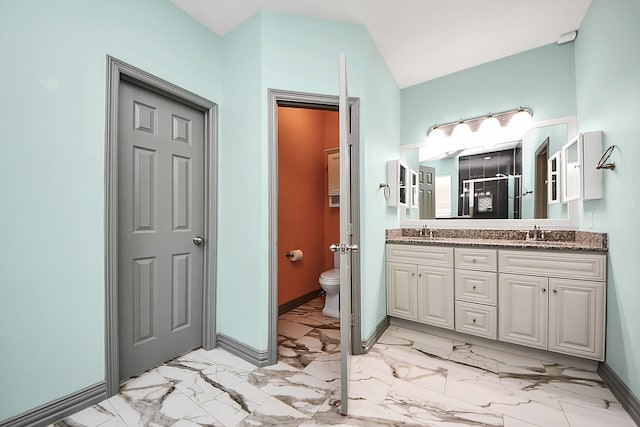 bathroom with marble finish flooring, toilet, double vanity, a stall shower, and baseboards