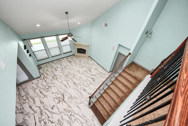 unfurnished living room with a fireplace, ceiling fan, lofted ceiling, stairs, and recessed lighting