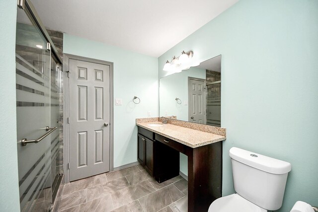 full bath featuring toilet, a stall shower, and vanity