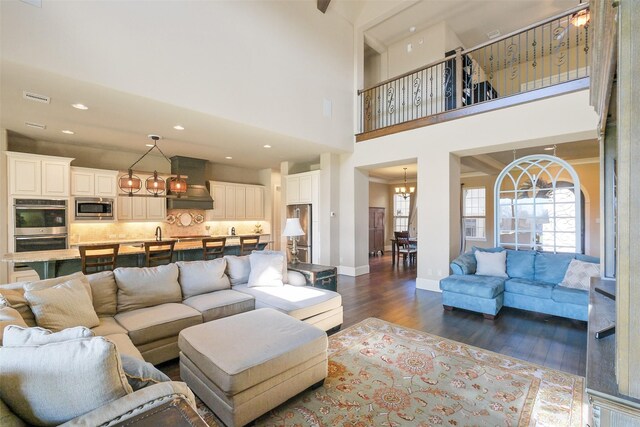 6919 Champion Trl, Katy, TX 77493 - living room with dark wood-style floors, a chandelier, baseboards, a high ceiling, and recessed lighting