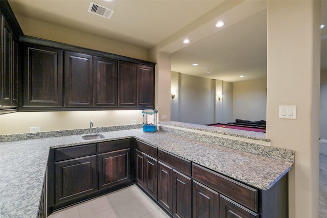 6919 Champion Trl, Katy, TX 77493 - kitchen with a sink, recessed lighting, a peninsula, light tile patterned floors, and dark brown cabinets